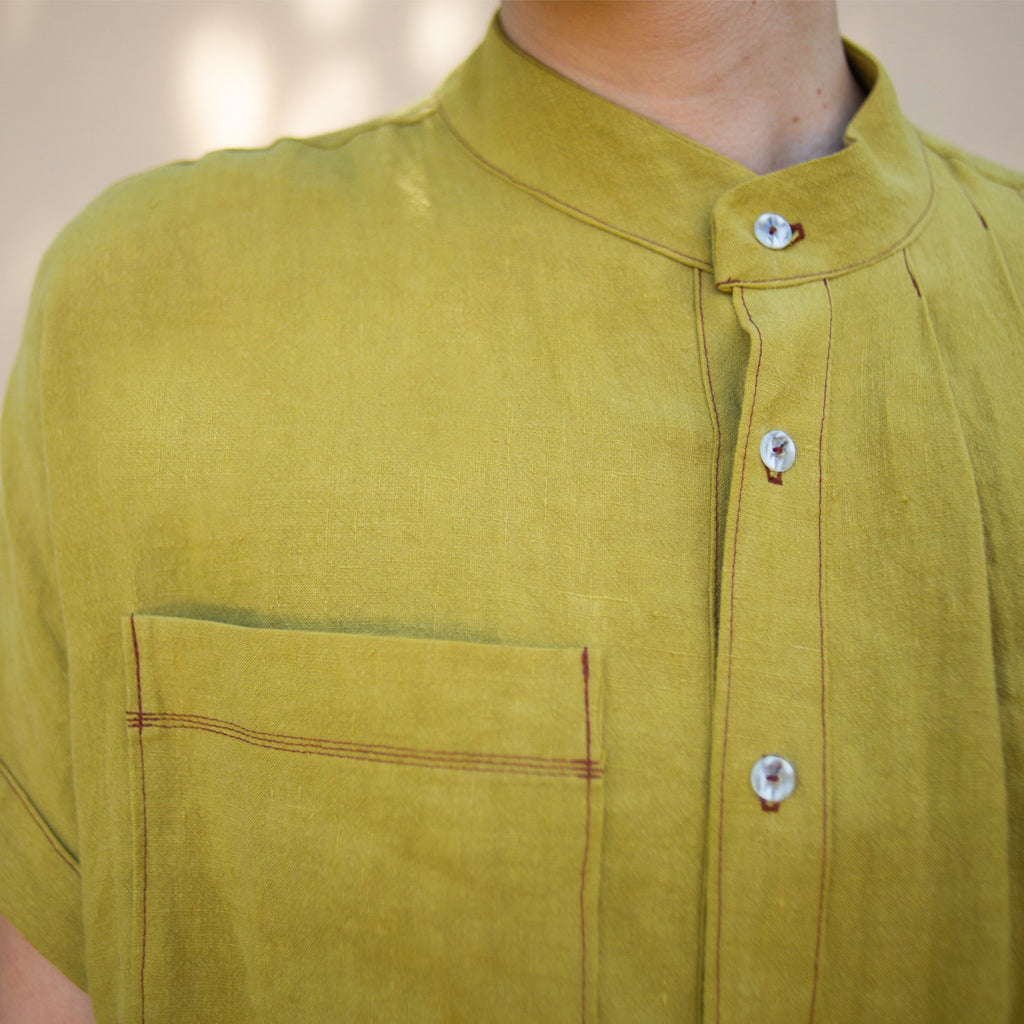 Close up showing details of the accent topstitching on the chest pocket and button placket.  Linen, Asymmetrical Pleated Shirt - Chartreuse. Made in California, USA by Rebecca Rae Design Inc.  Gender-Inclusive Clothing.