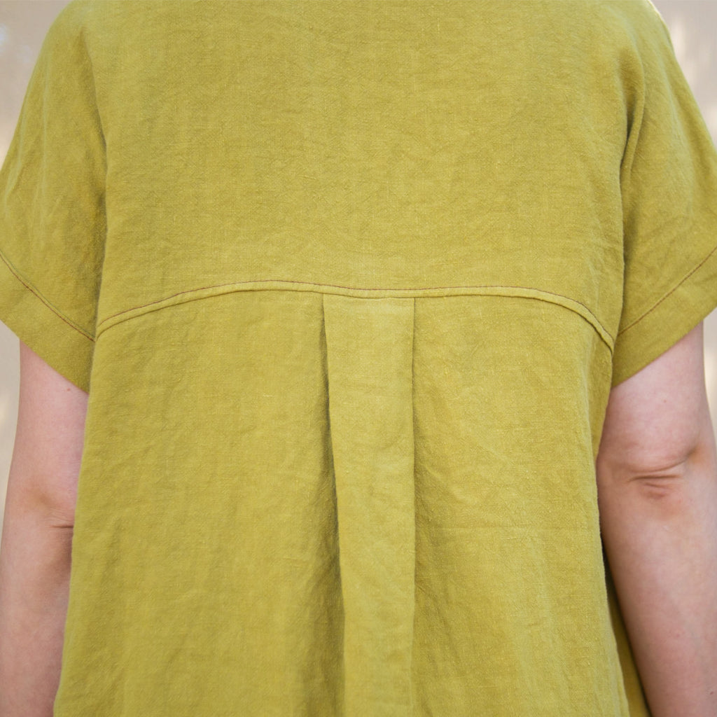 Close up showing details of the back yoke and box pleat. Linen, Asymmetrical Pleated Shirt - Chartreuse. Made in California, USA by Rebecca Rae Design Inc. Gender-Inclusive Clothing.
